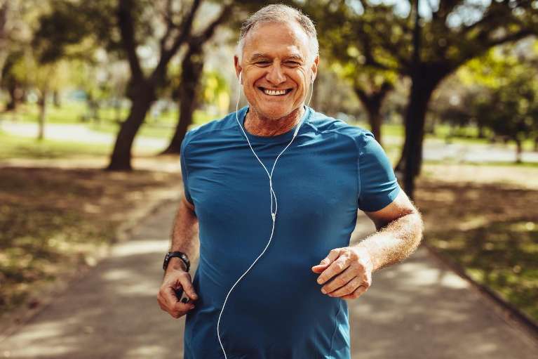  An elderly man running through a park, showcasing an active lifestyle amidst nature and fresh air.
