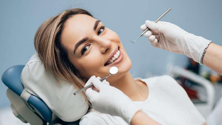 Woman in dentist chair smiling and getting her teeth cleaned, los gatos ca