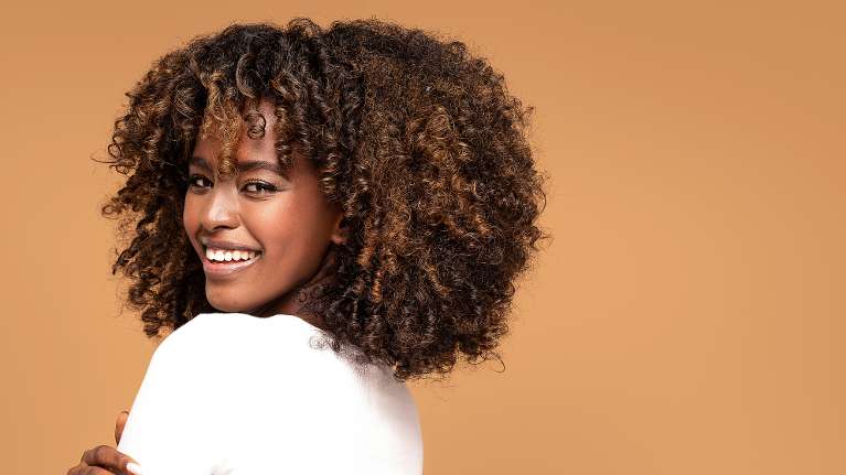 Confident woman smiling brightly representing a First Periodontal Visit