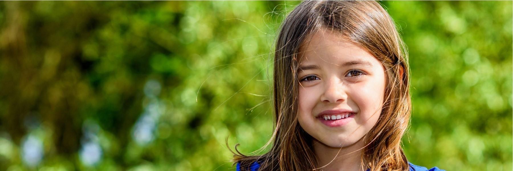 Little Girl Smiling with tree in background | Children's dentistry los gatos ca