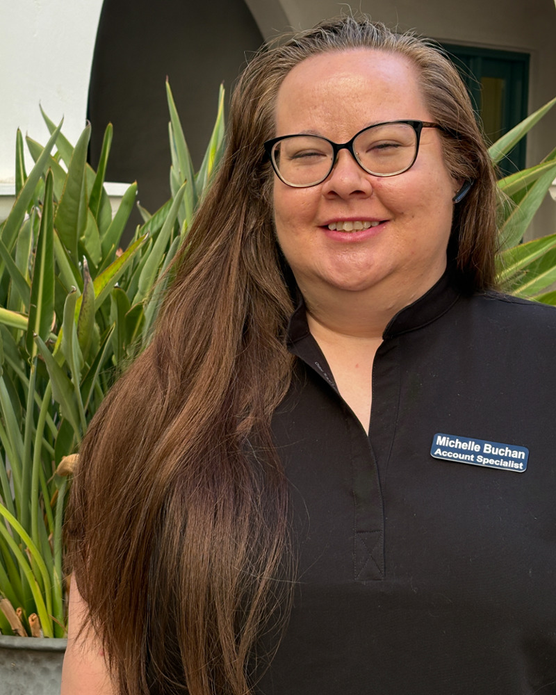 Michelle Buchan, Patient Account Lead at Nicole Pagonis DDS, smiling outdoors in black uniform with name badge